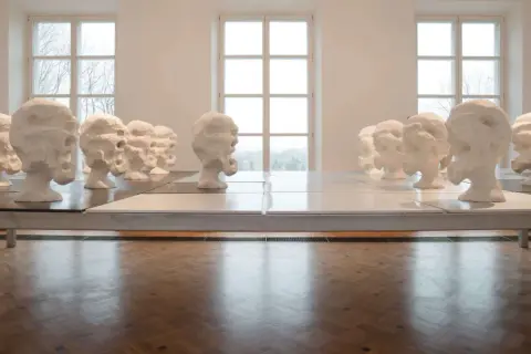 Rzędy białych, ekspresyjnych głów, dzieło Wandy Czełkowskiej, tworzą niepokojącą instalację w galerii.