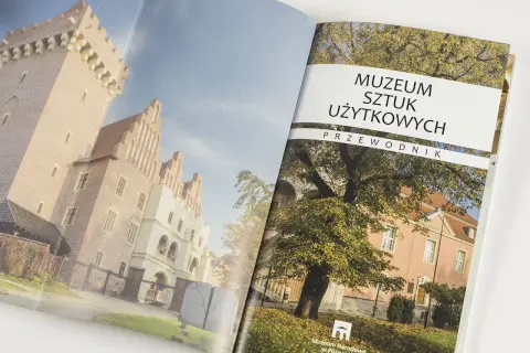 Przewodnik po Muzeum Sztuki Użytkowej w Poznaniu. Na okładce zabytkowe budynki i jesienne drzewa.