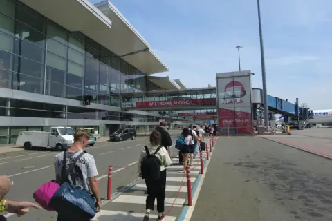 Kolejka pasażerów do odprawy na lotnisku. Długi czas oczekiwania może być frustrujący, ale warto uzbroić się w cierpliwość.