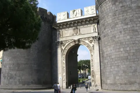 Le porte di Napoli storiche, un imponente arco trionfale tra torri massicce, accoglie visitatori e residenti.