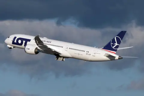 Biały Dreamliner LOT-u wznosi się na tle burzowych chmur. To dumny element polskiej floty lotniczej.