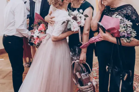 Wzruszający moment, gdy młoda para wręcza bukiety i kosz prezentów rodzicom. Może to część uroczystości, gdzie śpiewana jest oryginalna piosenka dla rodziców.