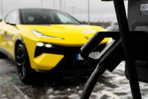 Gul elbil laddas vid en snabbladdare elbil.