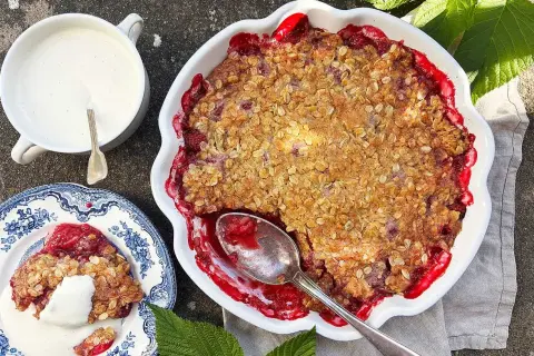 En härlig smulpaj med hallon, gyllene och krispig topping. Serveras med vaniljsås.