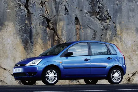 Niebieski Ford Fiesta 2005 zaparkowany przy skalnej ścianie.