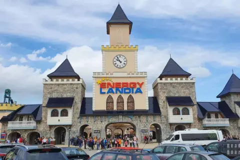 Wrocław Energylandia wita gości zamkową architekturą i kolorowym logo. Tłumy ludzi i zaparkowane samochody sugerują początek ekscytującego dnia.