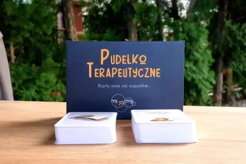 Pudełko terapeutyczne z kartami, które mogą być przykładowe formy terapii dziecka z zespołem Aspergera.
