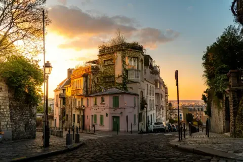 Rue pavée à Montmartre au coucher du soleil. Idéal pour une balade ou pour courir à Paris, avec ses maisons colorées et ses vues panoramiques.