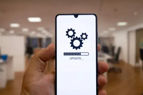 Telefon z ikoną aktualizacji i paskiem postępu. Może to być aktualizacja systemu **Android 16**.
