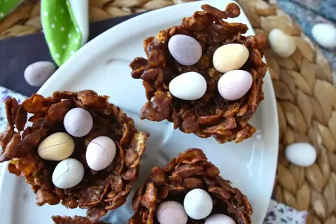 Délicieux nid de pâques en chocolat croustillant, garni d'œufs colorés. Parfait pour une chasse aux trésors gourmande.
