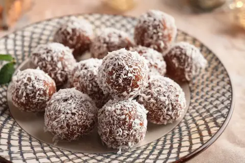 En tallrik med chokladbollar täckta av kokosflingor, redo att avnjutas. Ett enkelt chokladbollar recept för fika.