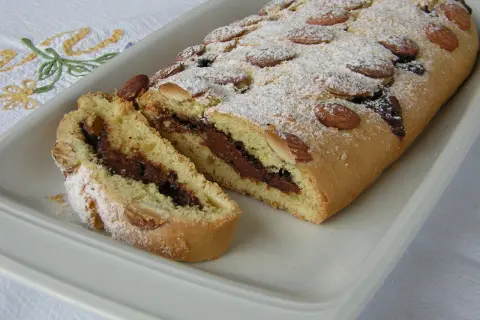 Ciambellone marchigiano con ripieno goloso di Nutella, decorato con mandorle e zucchero a velo.