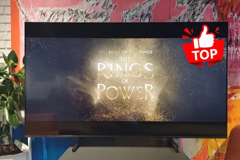 Na ekranie telewizora 1080p widać tytuł serialu "Władca Pierścieni: Pierścienie Władzy" na tle gwieździstego nieba.