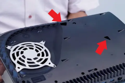 Rote Pfeile zeigen auf Lüftungsschlitze der PS5, die für die PS5 reinigen wichtig sind.