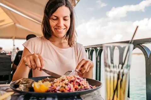Frau genießt Fisch mit Salat, eine Mahlzeit, die gut zur pescetarier bedeutung passt.