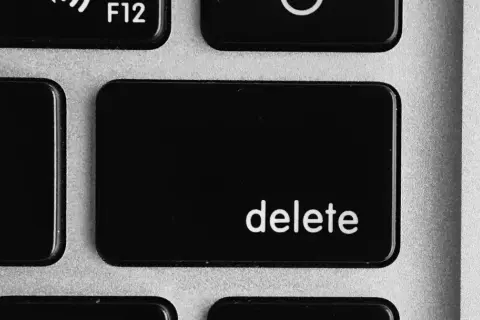 Close-up of a laptop keyboard showing the '+' and '=' keys, and the prominent 'delete' key.