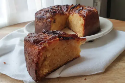 Un delicioso bizcocho de plátano y manzana, con una rebanada servida sobre una servilleta blanca.