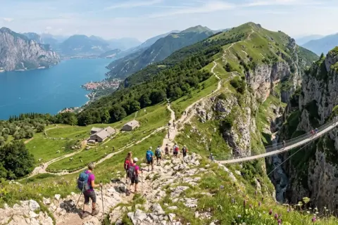 Sentiero panoramico tra i monti dell'Umbria, con escursionisti che attraversano un ponte sospeso su un profondo canyon.