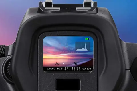 Il mirino elettronico mostra un tramonto mozzafiato sul mare, con impostazioni di scatto e istogramma.