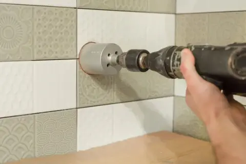 Precyzyjne wiercenie w płytkach ceramicznych za pomocą wiertarki udarowej z koroną.