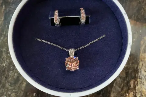 Eleganckie **Swarovski komplety**: naszyjnik z brzoskwiniowym kryształem i kolczyki w pudełku.