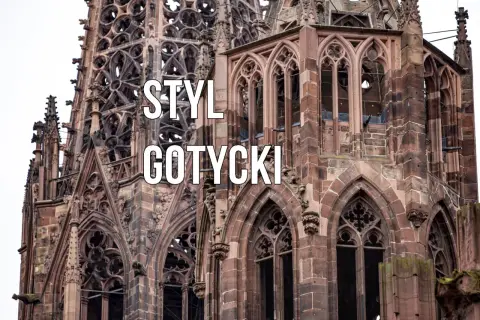 Kamienna katedra z ostrymi łukami, rozetami i gargulcami. Widoczne są charakterystyczne cechy stylu gotyckiego: strzelistość, bogactwo detali i monumentalność.