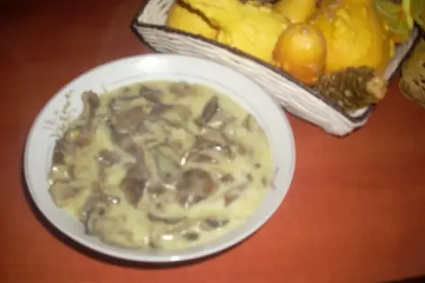 Talerz z kremowym sosem grzybowym, w tle koszyk z ozdobnymi dyniami.