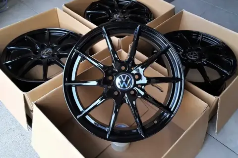 Cztery nowe, czarne felgi aluminiowe z logo VW, idealne do Golfa 4. Zastanawiasz się, jakie opony wybrać do swojego Golfa 4? Te felgi to świetny początek!