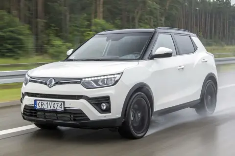 Biały SsangYong Tivoli na mokrej drodze. Wiele osób szuka ssangyong tivoli opinie przed zakupem.