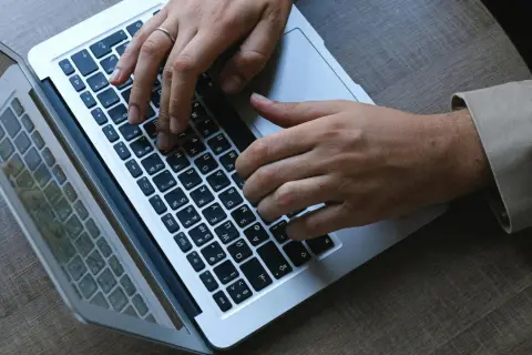 Dłonie piszą na klawiaturze laptopa. W stresującej sytuacji musimy się wszyscy uspokoic i skupić na zadaniu.