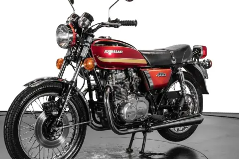 Clásica Kawasaki 400 antigua, roja y dorada, con motor expuesto y detalles cromados. Un icono de los 70.