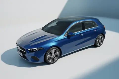 Un elegante Mercedes Clase A W177 azul metálico con techo panorámico, capturado en un estudio con iluminación suave.