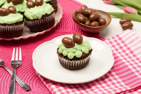 Schokoladen-Oster-Cupcakes mit hellgrüner Glasur und Schokoladen-Eiern, bereit zum Genießen.
