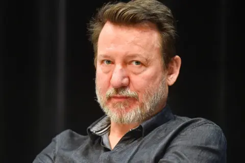 Robert Więckiewicz, znany z wielu filmów, seriali i programów, patrzy prosto w obiektyw.
