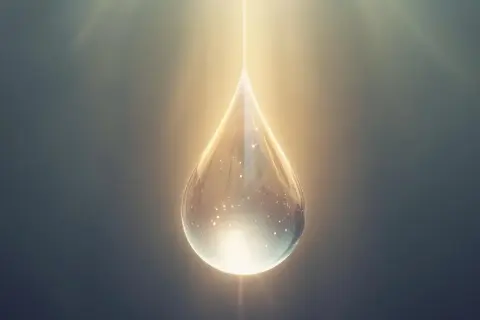 Goutte lumineuse, symbole d'espoir. Une goutte d'eau scintillante, baignée de lumière, évoque la question : peut-on guérir de la goutte ?