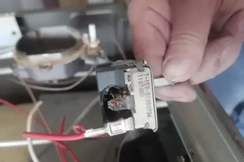 Uszkodzony termostat w piekarniku Mastercook do zabudowy. Widoczne ślady przepalenia.