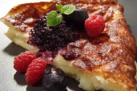 En bit fluffig tjockpannkaka med blåbärssylt, hallon och mynta. Ett perfekt recept för en härlig frukost eller fika.