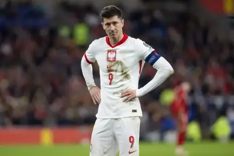 Robert Lewandowski w białej koszulce reprezentacji Polski, z numerem 9 na piersi i spodenkach.