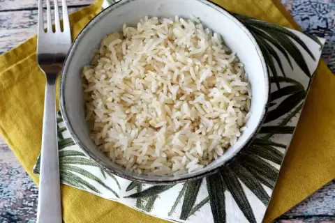 Schüssel mit lockerem Reis, daneben eine Gabel. Perfekt, wenn der Reis zu matschig ist, um ihn zu retten.