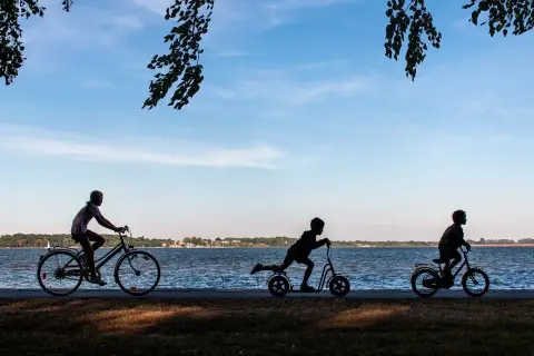 Dzieci na rowerach i hulajnogach nad jeziorem. Idealny rower dla 13 latka to taki, który zapewni mu radość z jazdy.