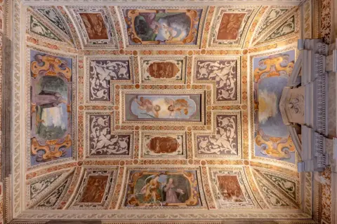 Soffitto affrescato della Certosa di Garegnano con scene sacre e decorazioni elaborate.