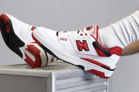 Scarpe New Balance 550 bianche e rosse, con logo "N" in evidenza. Le recensioni su new balance come calzano sono positive, offrono comfort e stile.