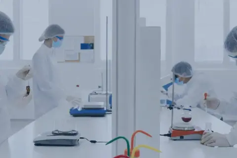 Wissenschaftler in Laborkitteln und Masken arbeiten an Experimenten, die für die Gerson Therapie relevant sein könnten.