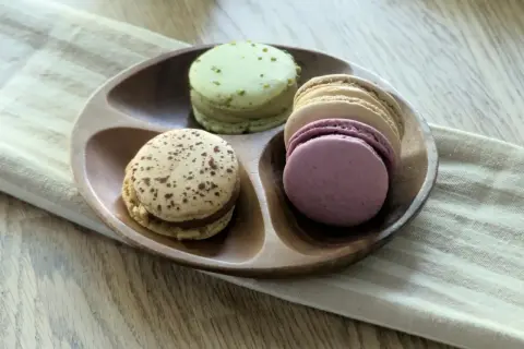Kolorowe makaroniki na drewnianej tacy, idealne do wypróbowania przepisu na makaroniki.