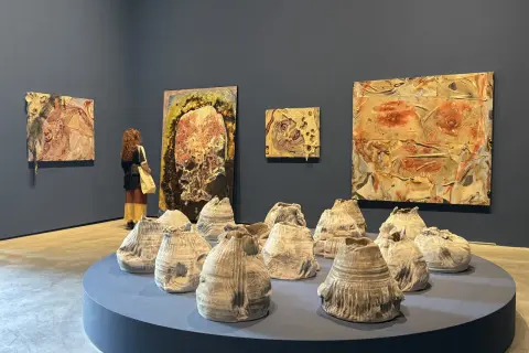 A visitor contemplates abstract artworks and ceramic sculptures at the Venice Biennale 2026.