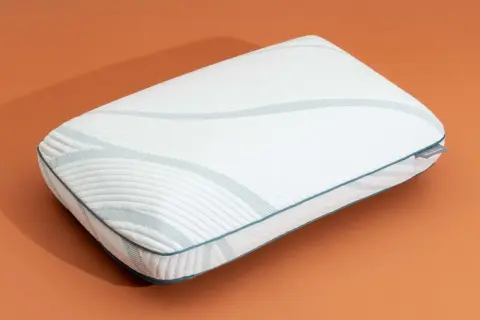A white memory foam pillow with blue trim and a textured pattern. Learn how to expand memory foam pillow for ultimate comfort.