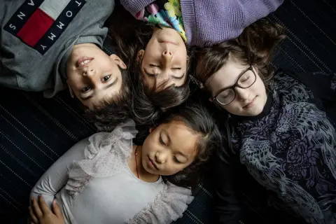 Fyra barn ligger tätt ihop. En 8-åring har svårt att somna, medan de andra verkar sova.