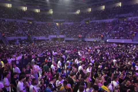 Multitud vibrante en el Pabellón Príncipe Felipe para disfrutar de conciertos. El recinto está lleno de gente, creando un ambiente festivo.