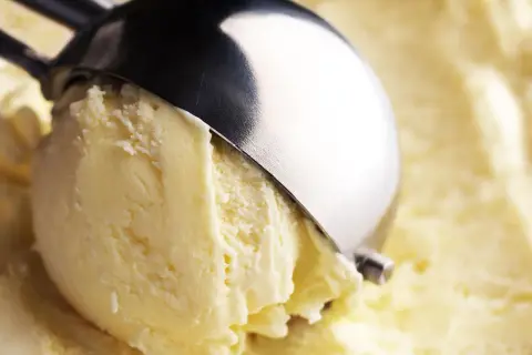 Un cucchiaio raccoglie un cremoso gelato, con un sapore che ricorda il latte condensato.