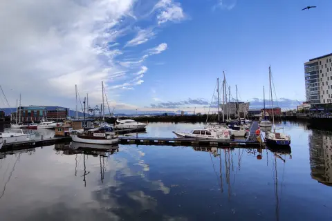 Port w Belfaście, gdzie jest? Widok na zacumowane jachty i łodzie pod błękitnym niebem z chmurami.